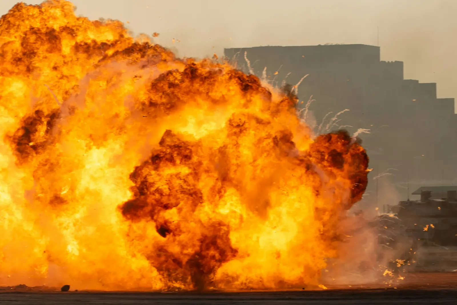 Großer Feuerball mit dunklem Rauch vor Gebäudesilhouetten als Bezug zum Startabbruch bei SpaceX und dem Druck auf die Aktie