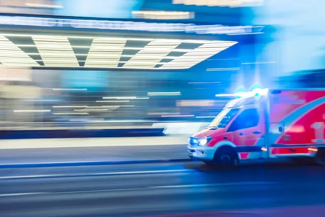 Rettungswagen mit Blaulicht fährt nachts durch die Stadt, aufgenommen in Bewegungsunschärfe, als Bezug zum turbulenten Börsenstart von GMR Solutions.