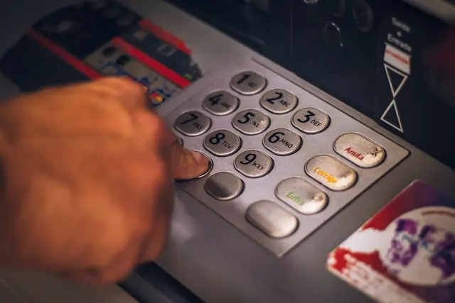 Eine Hand tippt eine PIN auf der Tastatur eines Geldautomaten, stellvertretend für das Bankgeschäft von Avidbank Holdings mit kleinen und mittleren Unternehmen in der Bay Area. 