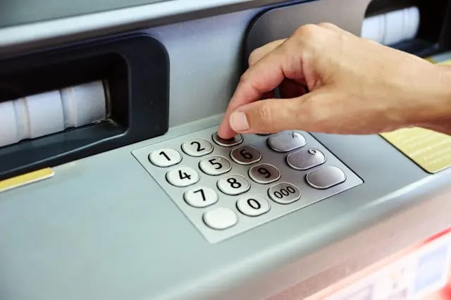Eine Hand tippt eine PIN an einem Geldautomaten – als Bezug zum Börsengang von Avidbank Holdings und dem Bankengeschäft des US-Instituts