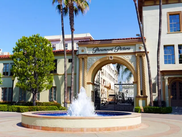 Historisches Eingangstor mit Schriftzug Paramount Pictures, Palmen und Springbrunnen als Bezug zur Übernahme von Warner Bros