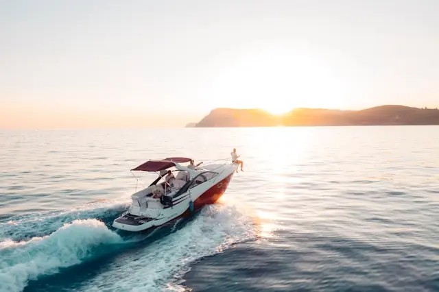 Weißes Motorboot mit Personen an Bord auf offener See bei Sonnenuntergang als Bezug zum Kurssprung von Twin Vee Powercats
