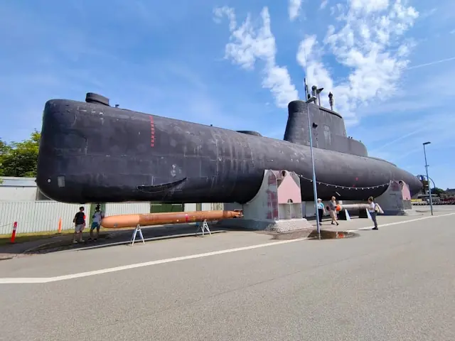 Ausgemustertes U-Boot steht als Museumsexponat an einer Straße, Besucher betrachten es, im Kontext des Scale-Börsengangs der Gabler Group.