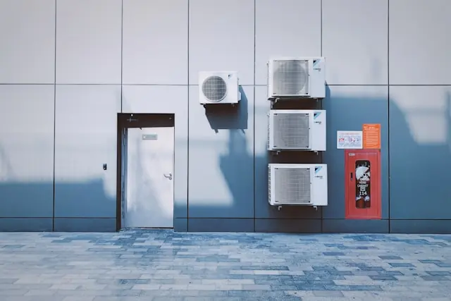 Vier Klimaaußengeräte der Marke Daikin hängen an einer Gebäudefassade, im Kontext des Mini-Börsengangs von Green Circle Decarbonize.