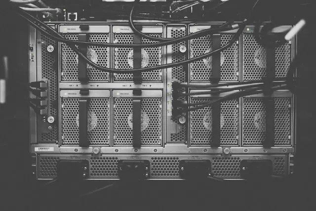 Schwarz-weiße Nahaufnahme mehrerer Server-Racks mit Kabeln in einem Rechenzentrum als Bezug zum Technologieunternehmen ChronoScale nach dem Kursanstieg durch den neuen Tesla-Veteranen.