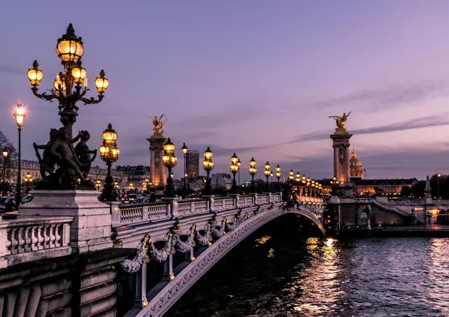 Beleuchtete Pont Alexandre III in Paris bei Abenddämmerung als Kulisse zum G7-Treffen und den Verhandlungen über Trumps Zollpolitik