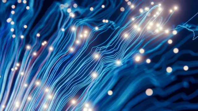 Leuchtende blaue Glasfasern mit hellen Lichtpunkten vor dunklem Hintergrund als Bezug zum KI-Anteil im MSCI World