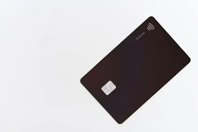 Dunkle Business-Kreditkarte mit EMV-Chip und NFC-Symbol auf weißem Hintergrund