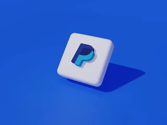 PayPal-Logo auf weißem 3D-Würfel vor blauem Hintergrund im Zusammenhang mit dem Übernahmepoker um den Zahlungsdienstleister