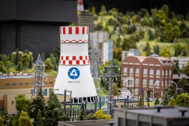 Miniaturmodell eines Kernkraftwerk-Kühlturms mit rot-weißem Streifenmuster in einer Diorama-Landschaft als Bezug zum Börsengang von NANO Nuclear