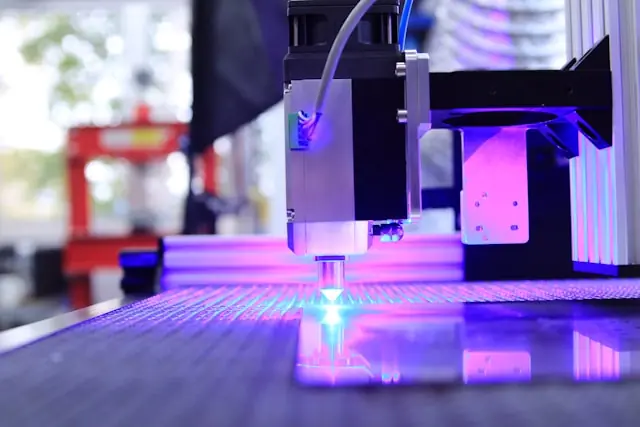 Laserschneidkopf mit violettem Lichtstrahl bei der Materialbearbeitung im Kontext des NYSE-Börsengangs von Voyager Technologies