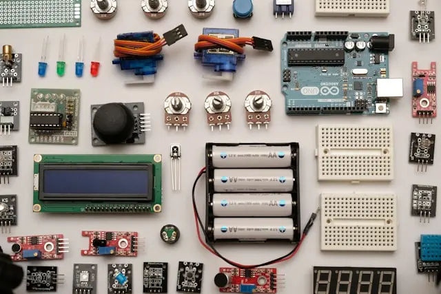 Arduino-Board, Servomotoren, Sensoren und Steckplatinen auf hellem Untergrund als Bezug zu Jabils Elektronikfertigung und KI-Infrastruktur