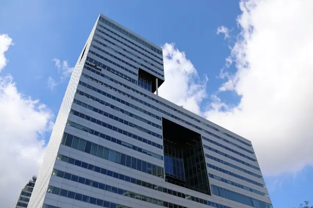 Moderner Büroturm mit Glasfassade aus der Froschperspektive vor blauem Himmel, im Kontext der anstehenden Quartalszahlen von Accenture