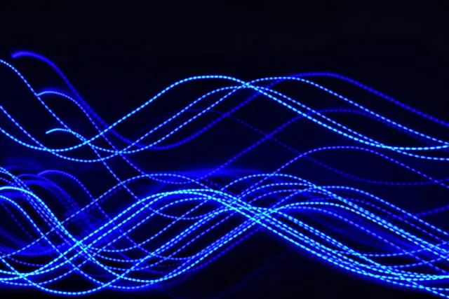 Wellenförmige blaue Lichtlinien vor schwarzem Hintergrund als Anspielung auf Datenströme rund um das SK-hynix-Listing an der Nasdaq