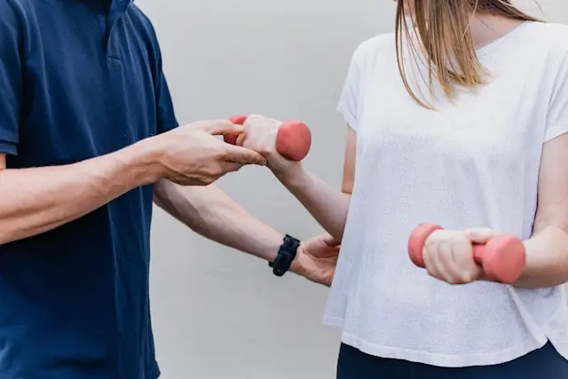Zwei Personen beim Training mit roten Hanteln als Bezug zum NYSE-Börsengang des digitalen Physiotherapie-Anbieters Hinge Health