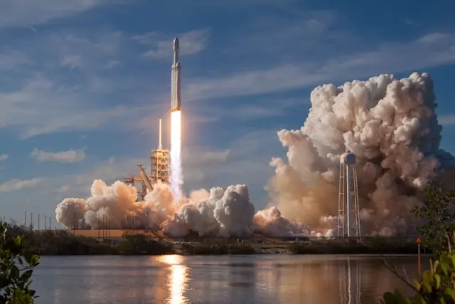 Startende Trägerrakete mit Rauchwolken und Wasserturm im Hintergrund, im Bezug zum IPO von Applied Aerospace and Defense 2026