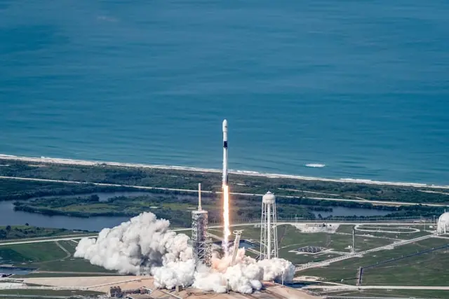 Startende SpaceX-Rakete mit Abgasfahne über einer Startrampe an der Küste als Bezug zum geplanten Nasdaq-Börsengang