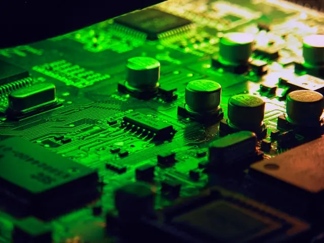 Grün beleuchtete Platine mit Kondensatoren und Chips in Nahaufnahme als Bezug zu den Insiderverkäufen bei Aehr Test Systems